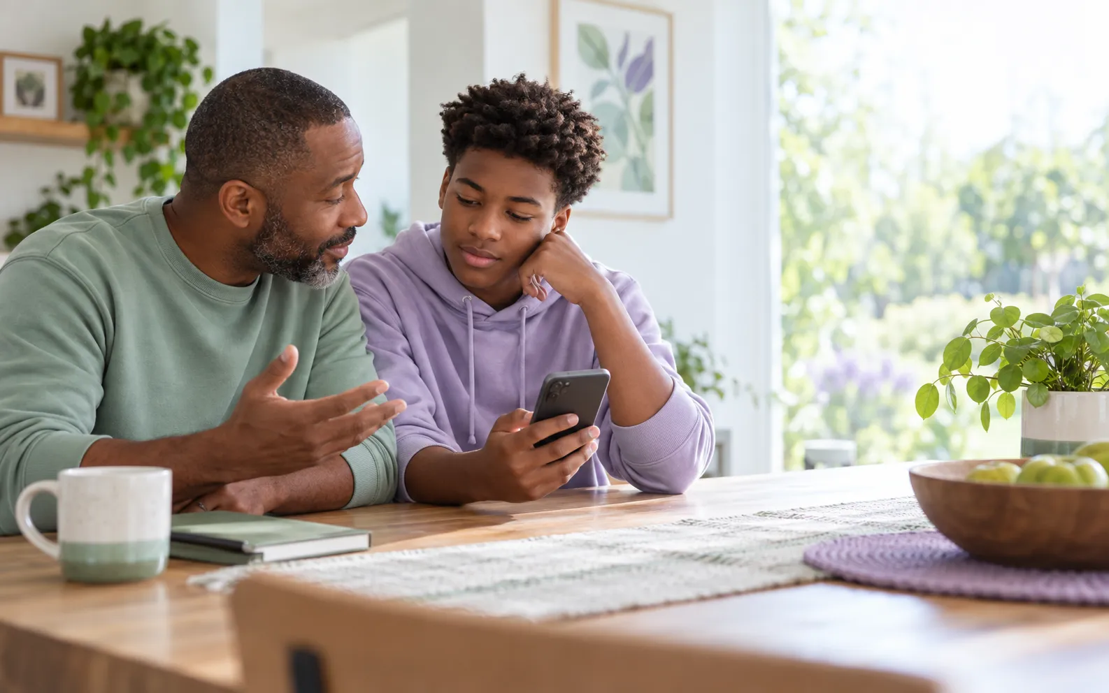 Father and teenage son openly reviewing a difficult WhatsApp conversation together